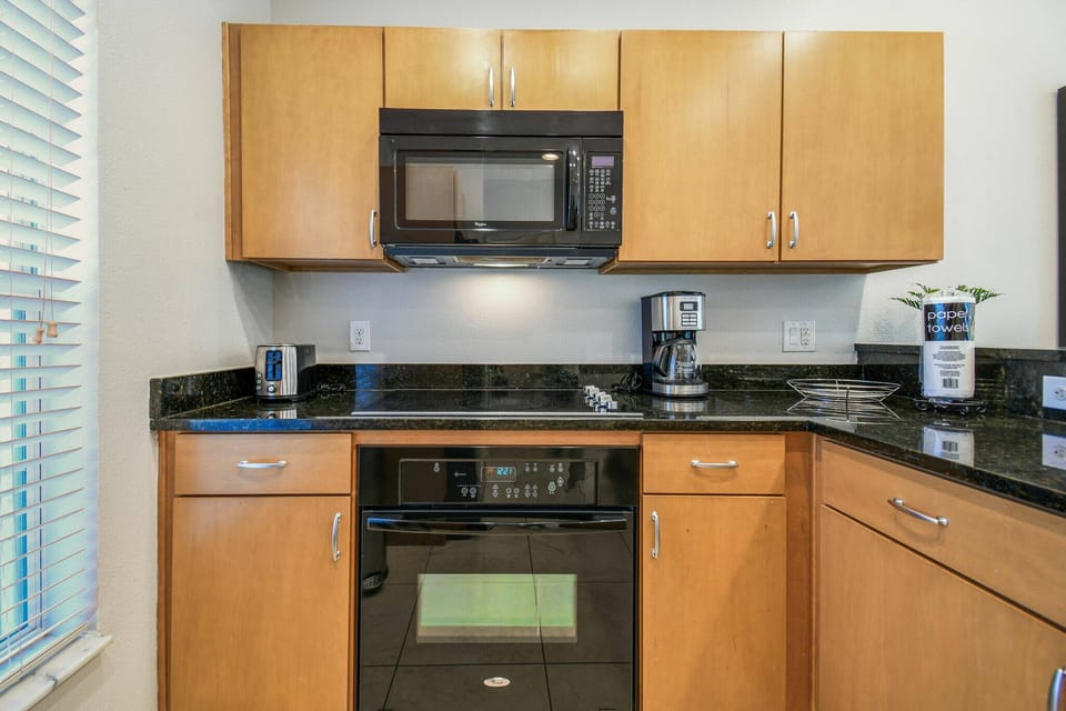 This kitchen features elegant black granite countertops and warm wooden cabinetry, creating a functional space for your cooking. With modern appliances and plenty of natural light, it's ideal for your culinary adventures.
