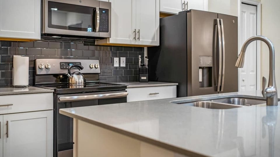 Modern kitchen with sleek stainless steel appliances, quartz countertops, and a stylish backsplash. Fully equipped and perfect for cooking family meals or entertaining guests.