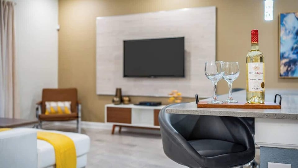 Stylish living space with a modern TV setup, cozy seating, and warm decor. A chic bar area with wine and glasses adds a touch of luxury, making it the perfect spot to unwind after a day of adventure.