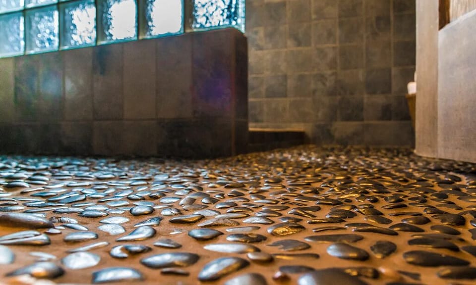 The main bathroom has a walk-in shower with therapeutic black stones inlaid into the floor providing a spa-like experience.