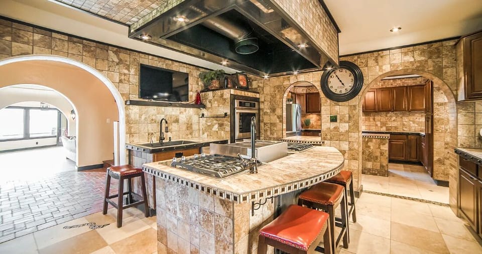 The Chef Kitchen's large island boasts 8 gas burners, a convenient pot filler, and indoor grill with gleaming countertops to an array of top-of-the-line appliances.