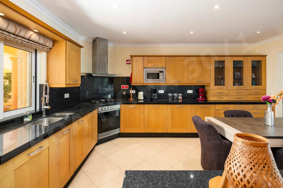 Modern kitchen with oven, microwave, coffee machine, and ample worktop space at Boa Nova 30/1, Carvoeiro, Algarve