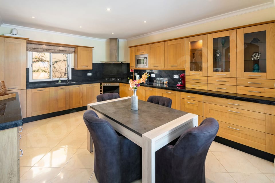 Fully equipped kitchen with dining area, oak cabinets, and granite worktops at Boa Nova 30/1, Carvoeiro, Algarve