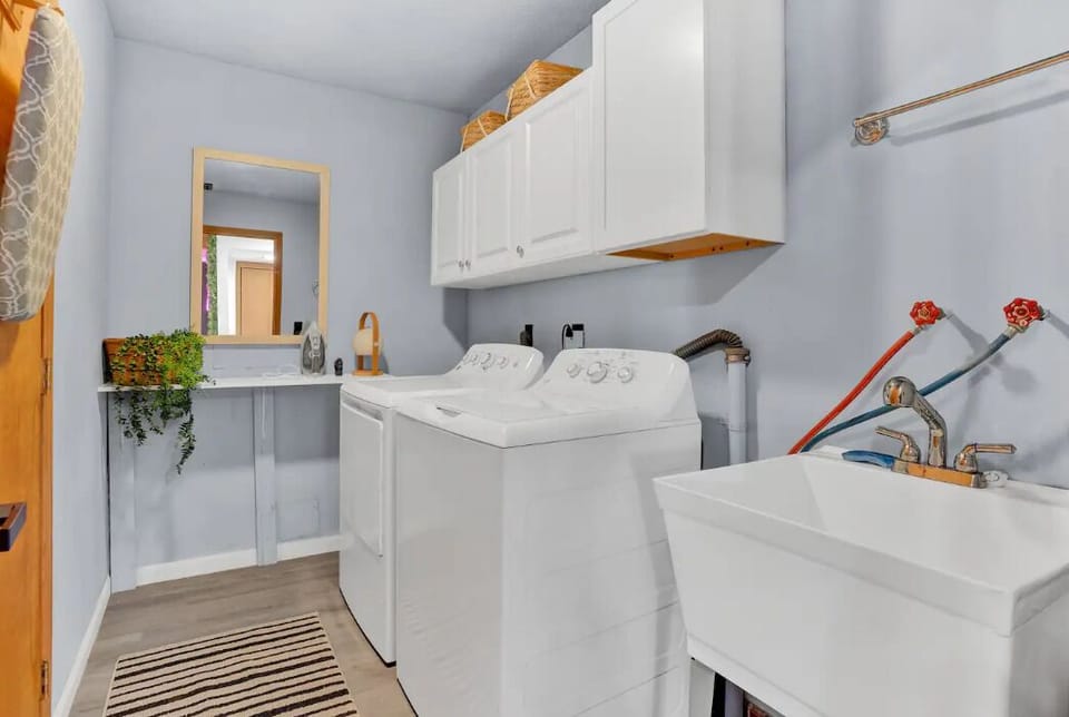 Laundry room with washer, dryer, iron, iron table & utility sink.
