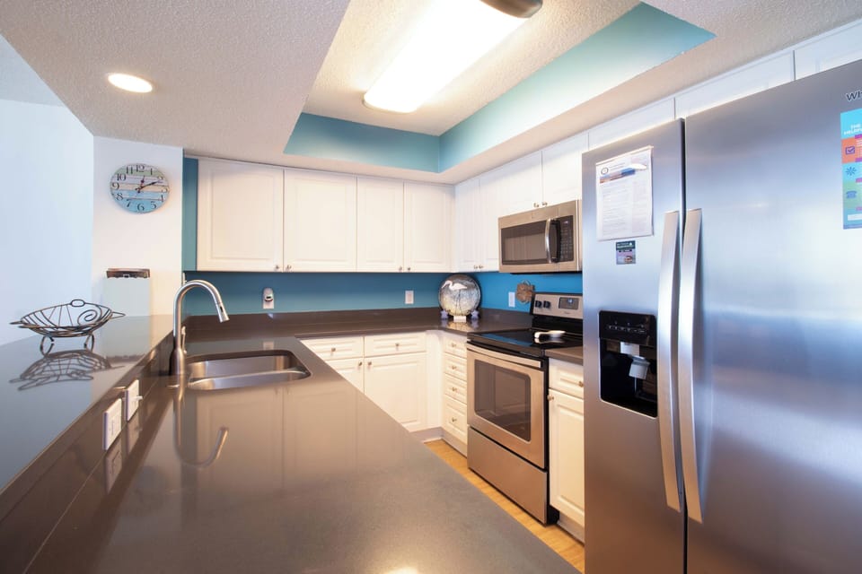 Your fully equipped kitchen features sleek stainless steel appliances and granite counters, perfect for preparing vacation meals together.