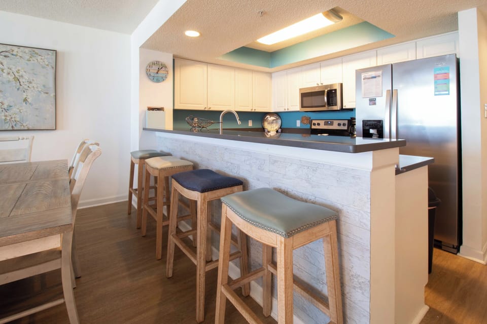 Your fully equipped kitchen features modern appliances and a breakfast bar where you can enjoy morning coffee or casual meals together.