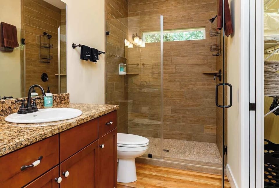 The master bathroom features this large tiled walk-in shower. A shampoo, conditioner and body wash dispenser is mounted on the back wall of the shower.