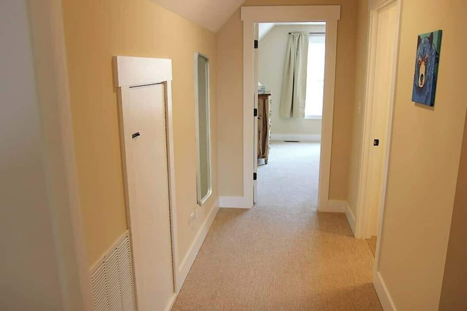 This short hallway connects the two upper bedrooms and provides access to the upper level bathroom.