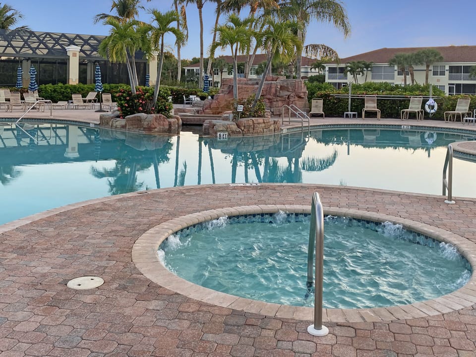 Hot tub, pool and view of rocks and exterior of lap pool