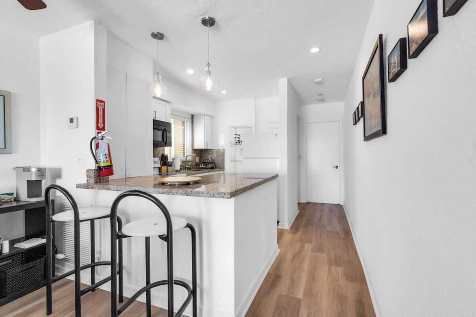 Start your day with coffee and coastal charm! This vacation rental features a sleek kitchen, comfy barstools, and a welcoming layout for easy living.