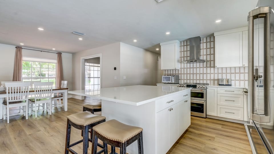 As seen in the picture, the kitchen comes stocked with a microwave, toaster, and double oven. It also offers a large island to eat at.
