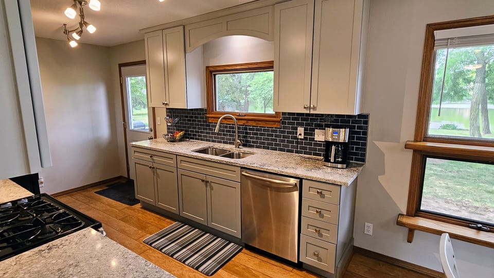 Kitchen with quartz countertops, double oven, and full complement of cookware.