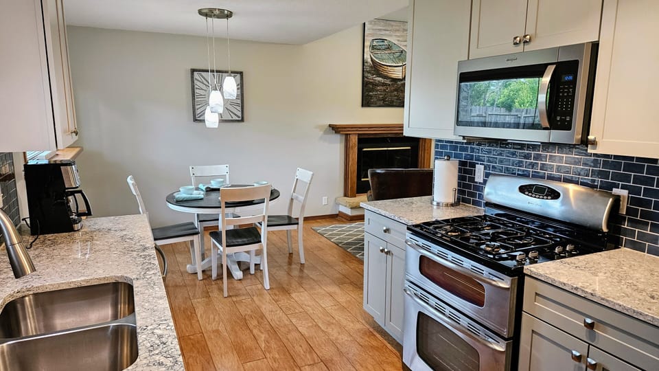 Kitchen with quartz countertops, double oven, and full complement of cookware.