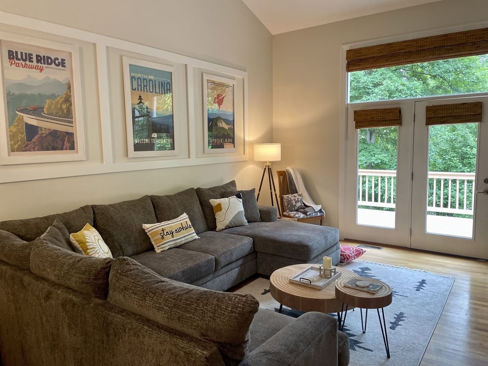 Living room leads out to upper deck with grill and seating.