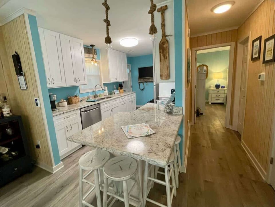 Kitchen with open bar and 4 stools to seat up to 12 for sit-down meals