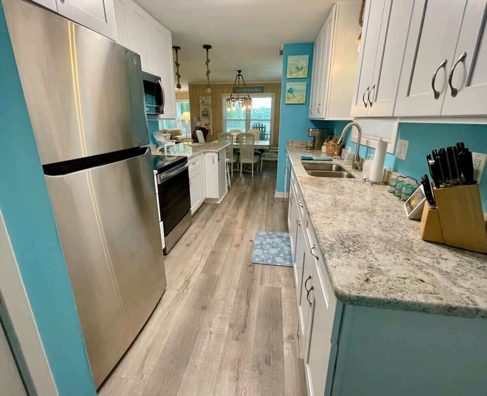 Kitchen view looking from the back door equipped with all new appliances, toaster, Keurig, and full-size stack washer/dryer in the closet to the left.