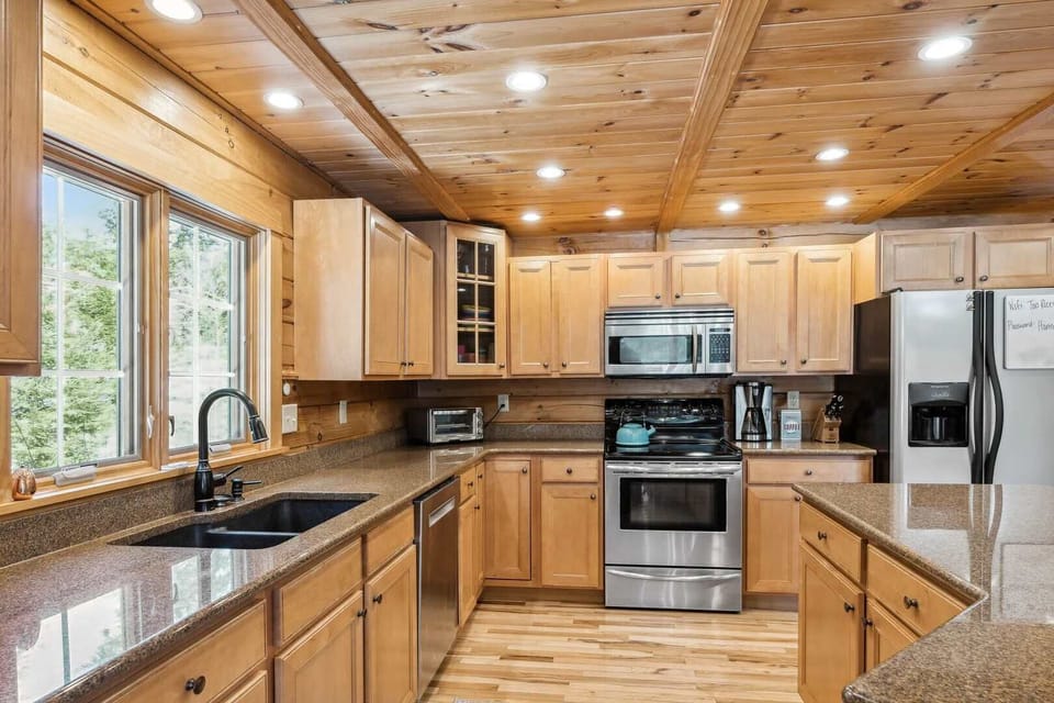 Spacious kitchen with maple cabinetry,
    granite counters, gas stove, and ample
    prep space for group meals