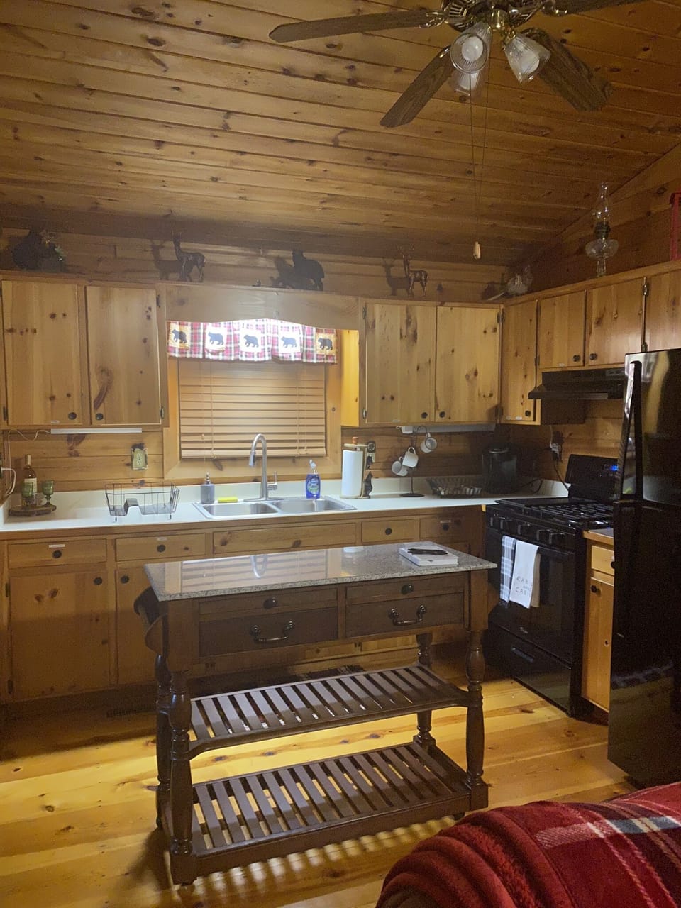 Kitchen stocked with cooking  supplies and utensils, plates and glasses