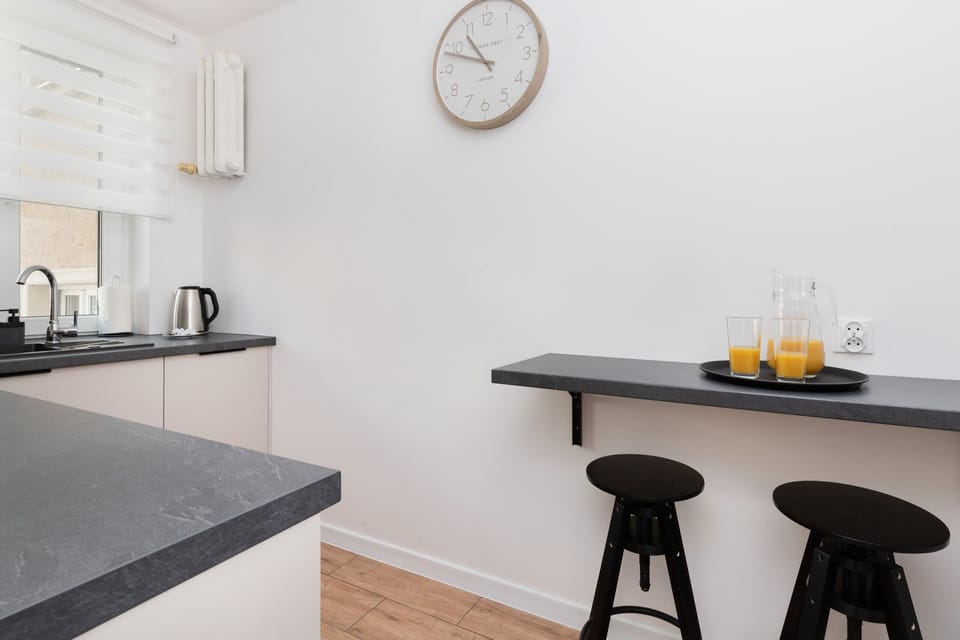 A view of the kitchen and dining area with bar stools, creating a versatile and modern layout.
