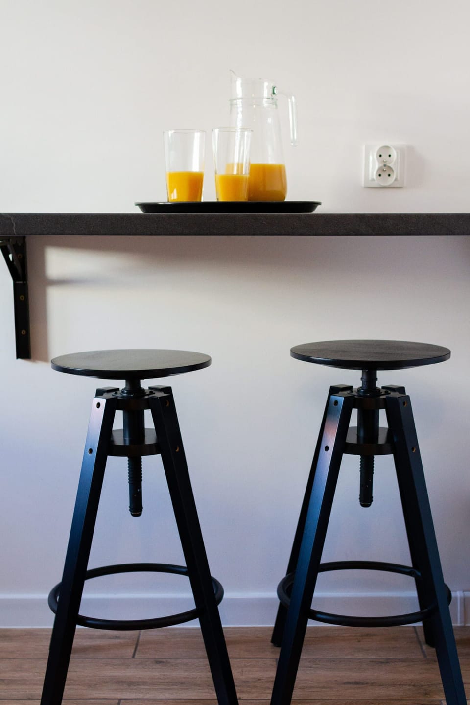 A close-up of a kitchen counter with bar stools, offering a casual spot for dining or work.
