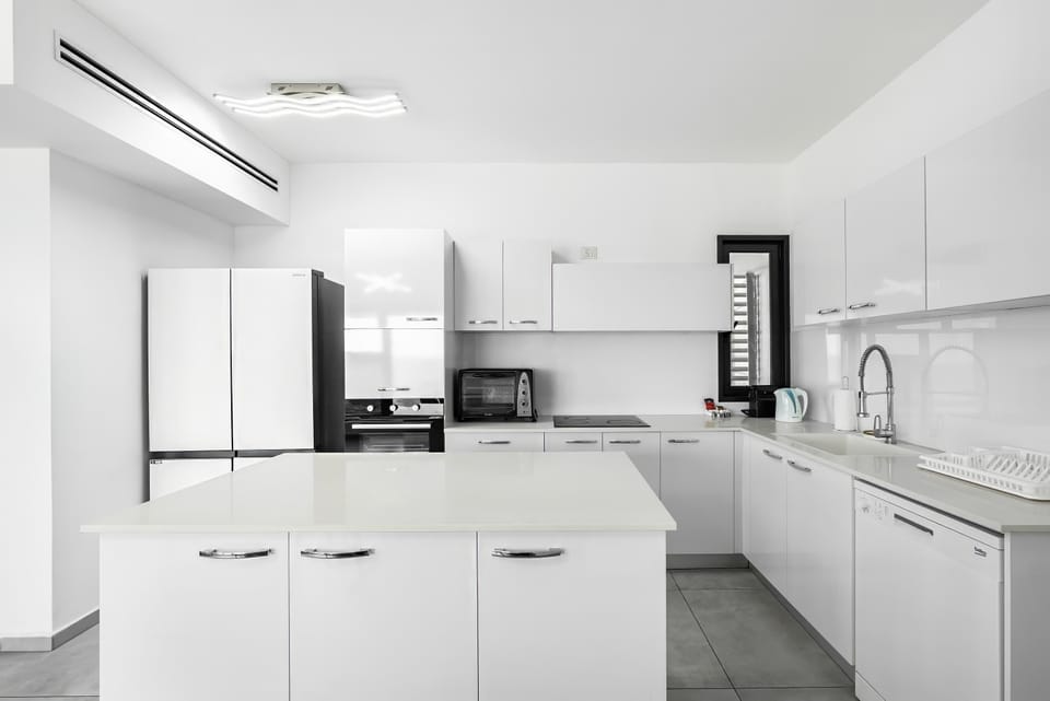 Sleek all-white kitchen makes cooking effortless, with generous workspace for breakfasts, snacks, and shared dinners.