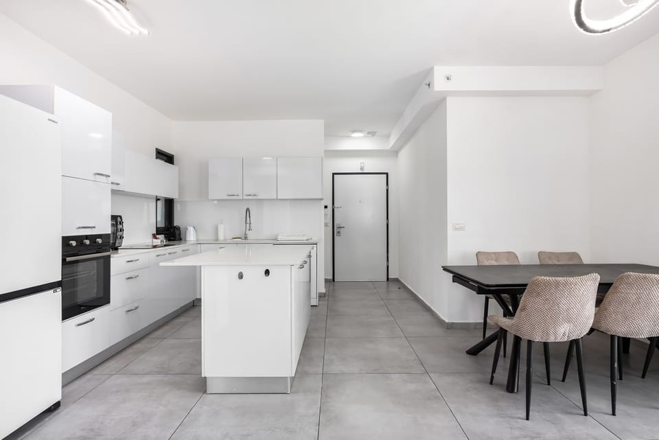Dining nook beside the kitchen makes mornings seamless before heading downstairs to shops and shoreline.