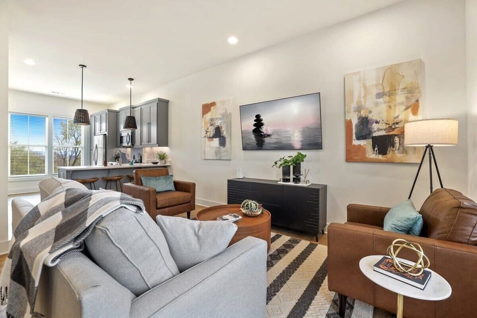 This space has a gray couch, two leather lounge chairs and a 65-inch Samsung Smart TV.