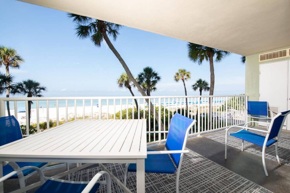 Ocean-view balcony w/ blue seating, palm-lined scenery, & space to unwind outdoors.