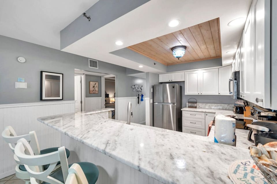 Open kitchen & bar area w/ spacious counters, ideal for cooking, prepping, & gathering together.