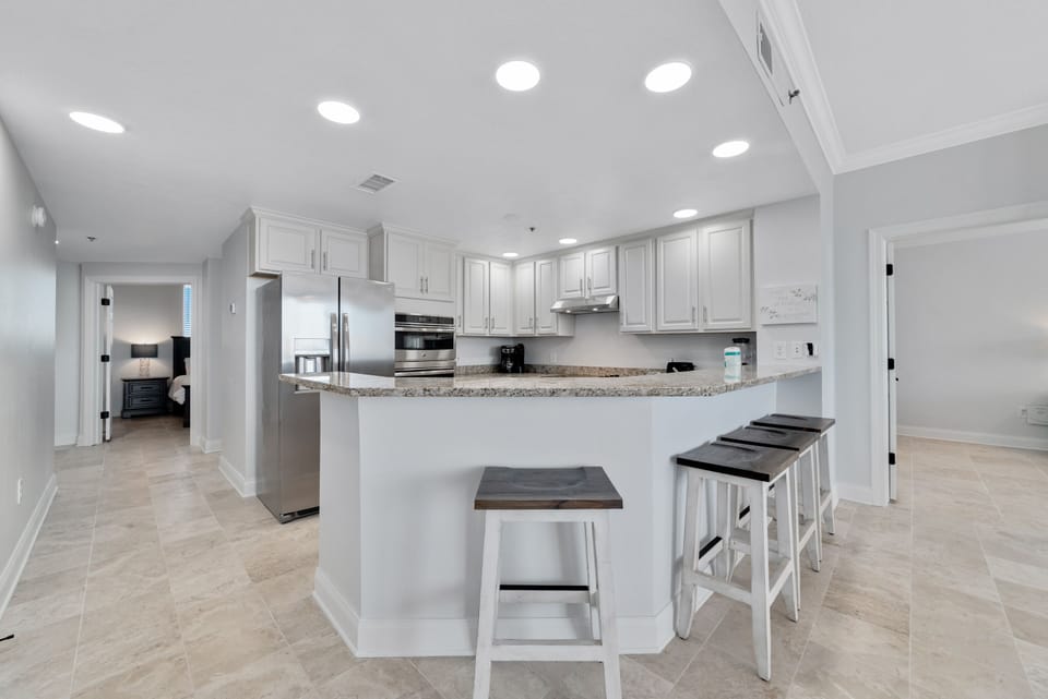 This spacious kitchen bar with seating for four is the perfect spot for casual meals, morning coffee, or gathering with friends. It's the ideal space to socialize while keeping the chef company.