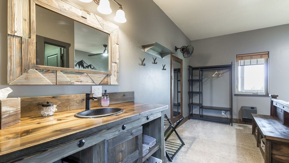 Enjoy our rustic ambiance featuring custom-made, expertly crafted oversized vanities. This uniquely designed furniture offers ample storage space, providing a convenient and stylish solution to store all your travel essentials. (Room 3)