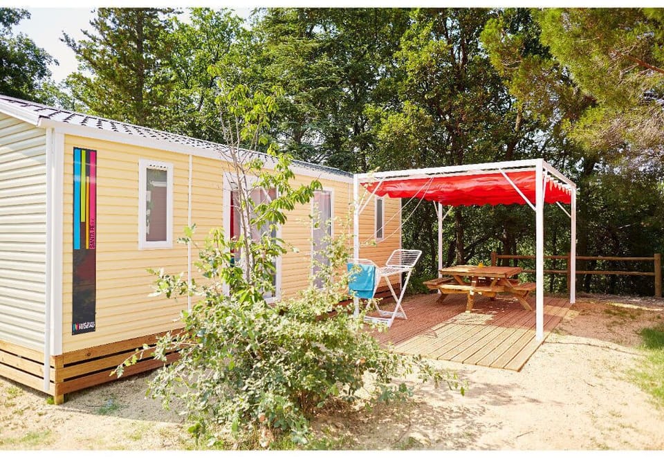 Cozy camping home with a shaded outdoor seating area, ideal for enjoying fresh air.
