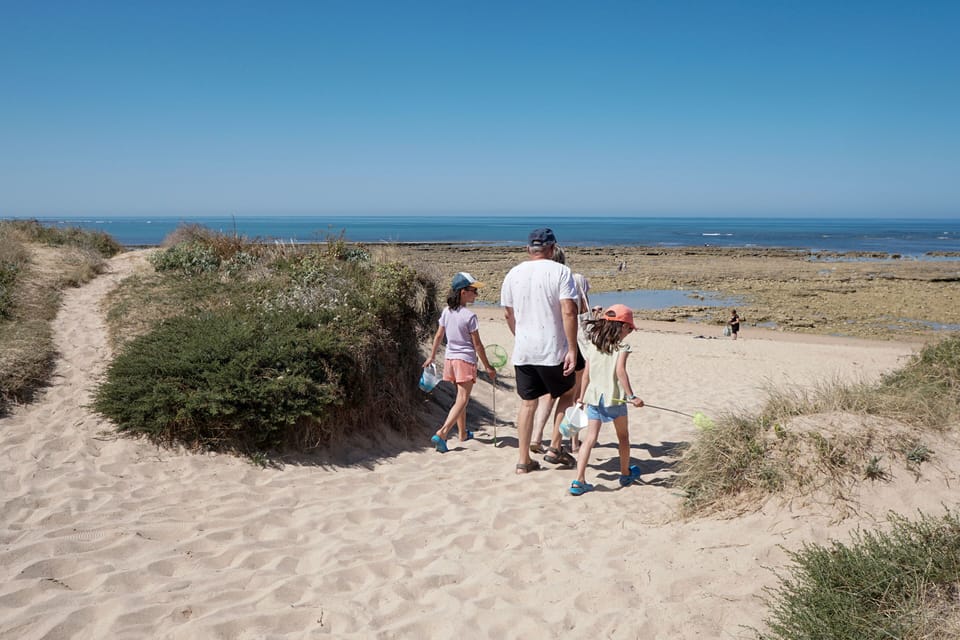 Guests stroll through soft dunes toward the Domino Beach, just steps from the resort.