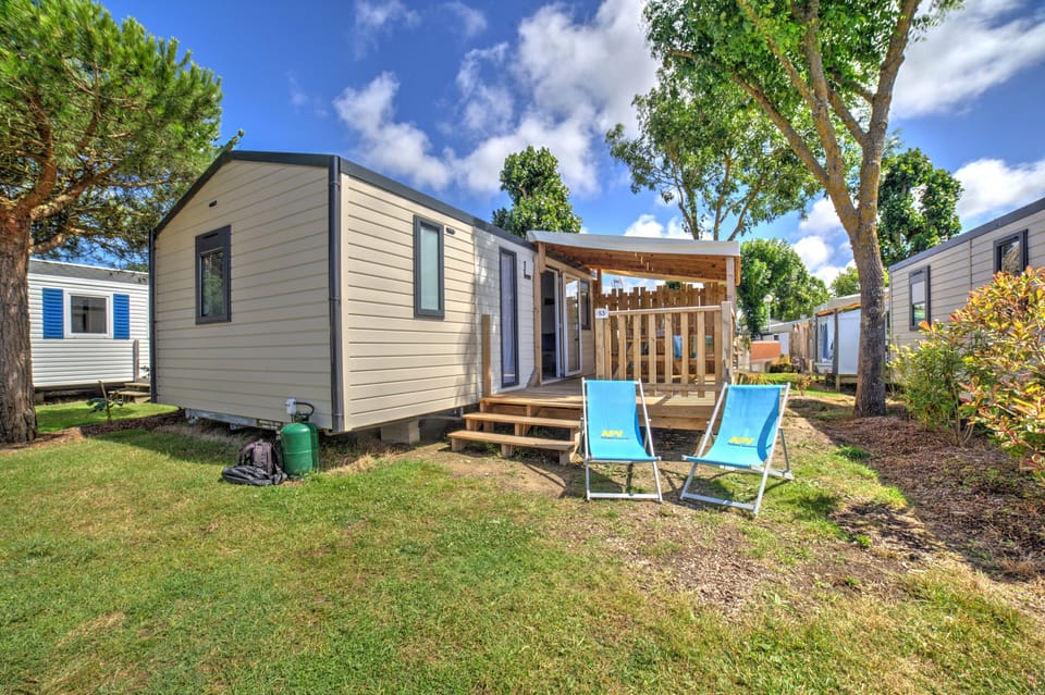 Embrace sunny days in this inviting outdoor space, perfect for lounging and unwinding amidst greenery and blue skies.