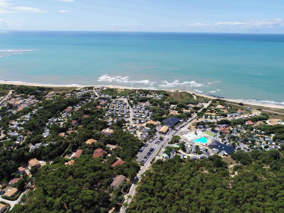 A sweeping aerial view captures L’Anse des Pins’ prime location between sea and forest.