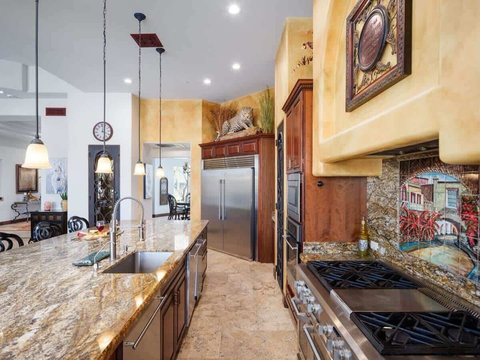 Stunning gourmet-style kitchen with stainless steel appliances, large island, breakfast table, and is fully equipped with your basic cooking essentials.