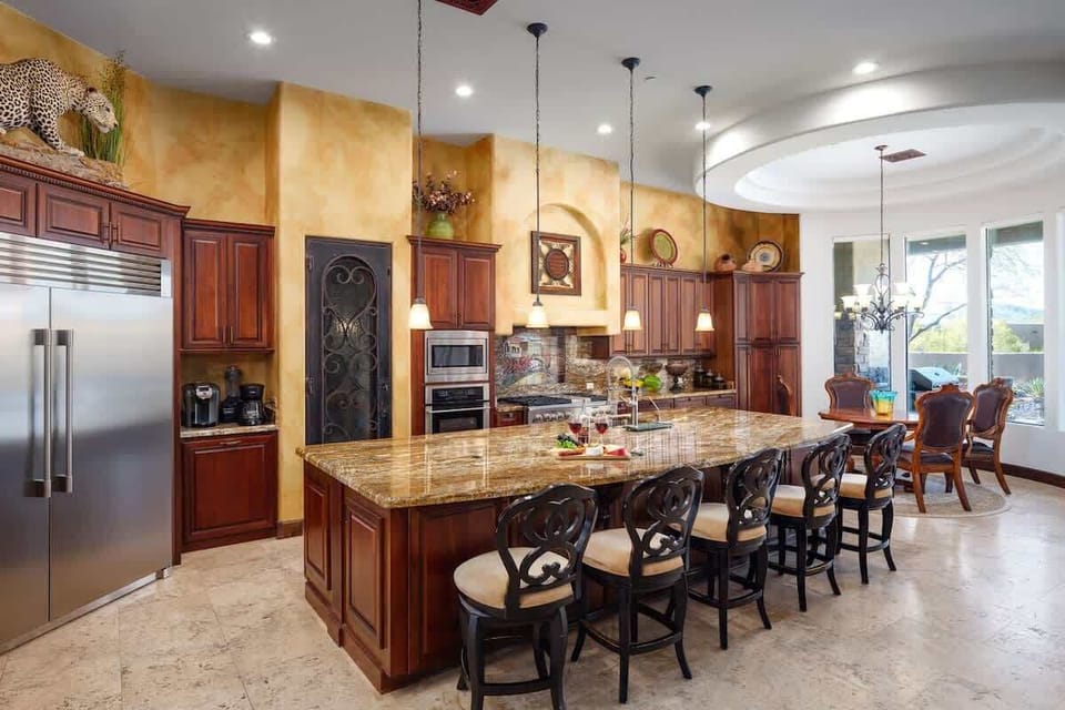 Stunning gourmet-style kitchen with stainless steel appliances, large island, breakfast table, and is fully equipped with your basic cooking essentials.