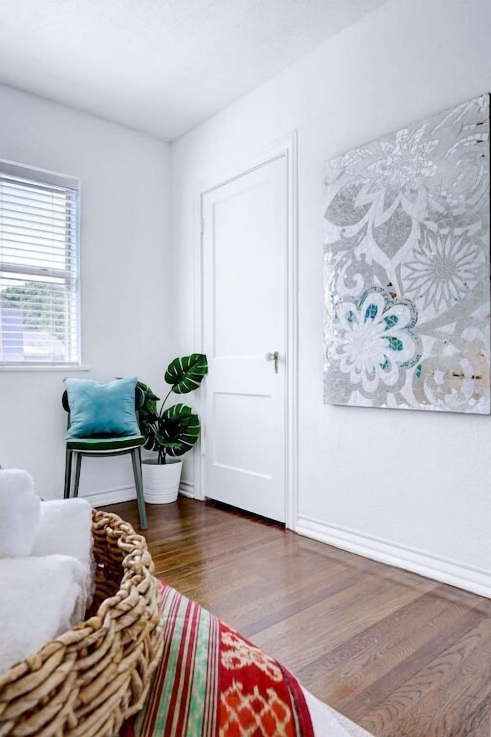 A neatly arranged bunch of towels, stunning wall art and lush indoor plant brings life and freshness to the space.