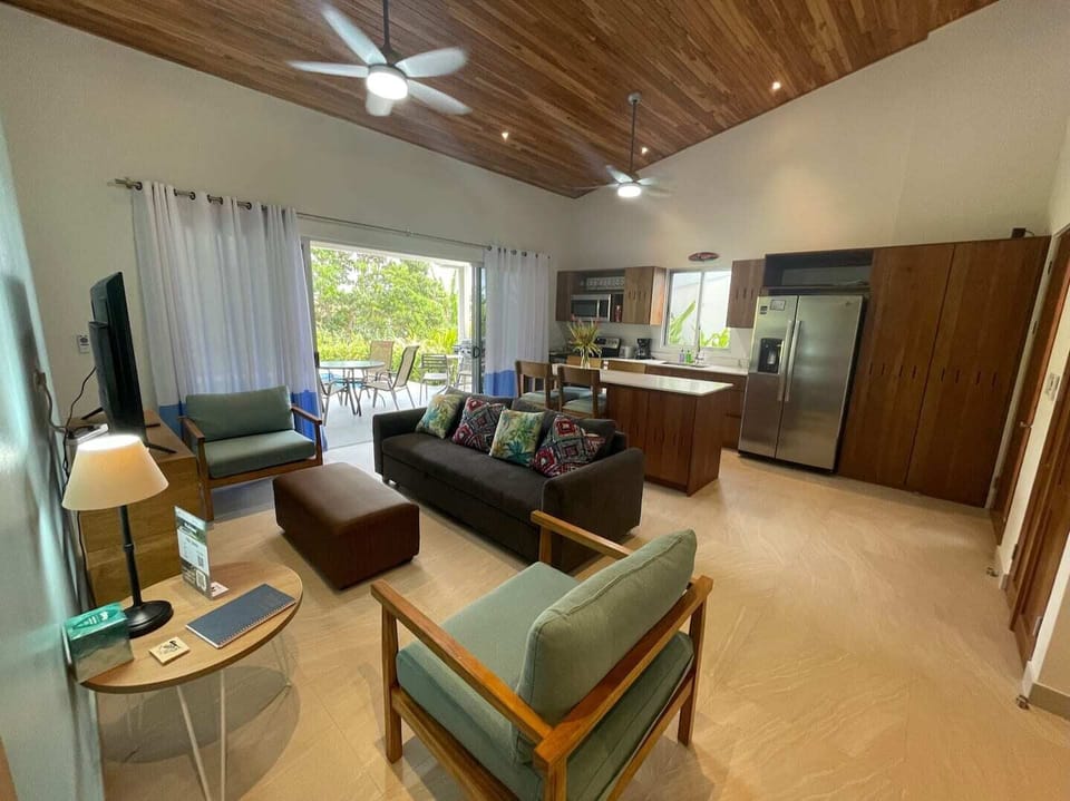 Amazing living room and kitchen with access to the patio and the pool. The living room has ceiling fan.