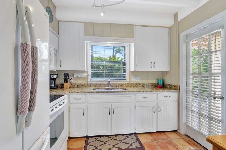 There is Granite Counters in the Kitchen As Well as White Cabinets