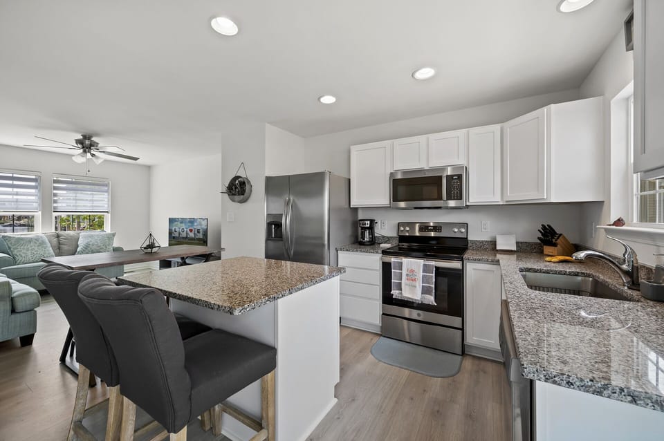 Well-Stocked Kitchen with gleaming Granite and Stainless Appliances.