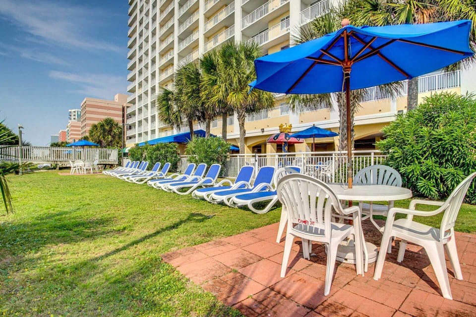 Relax in style with comfortable lounge chairs and shaded tables, perfect for enjoying the outdoors. Whether soaking up the sun or unwinding with a meal, this space is ideal for a peaceful retreat. 