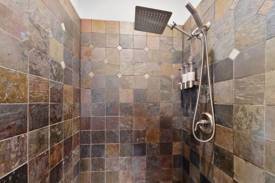 Main floor shower with rain showerhead and handheld wand. Great water pressure.