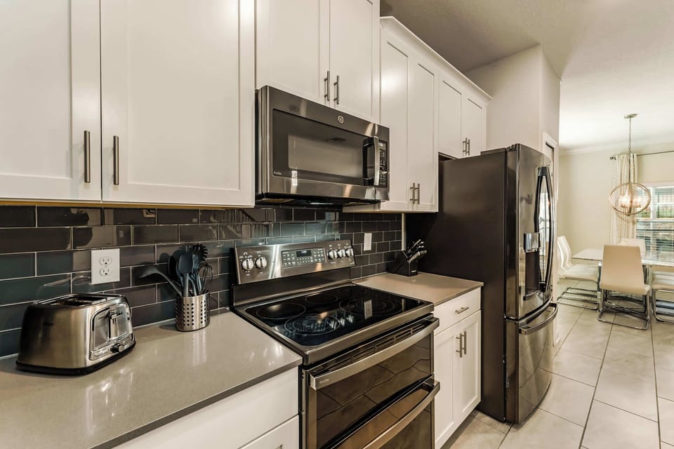 Sleek, modern kitchen with stainless steel appliances and a cozy dining area perfect for family meals.
