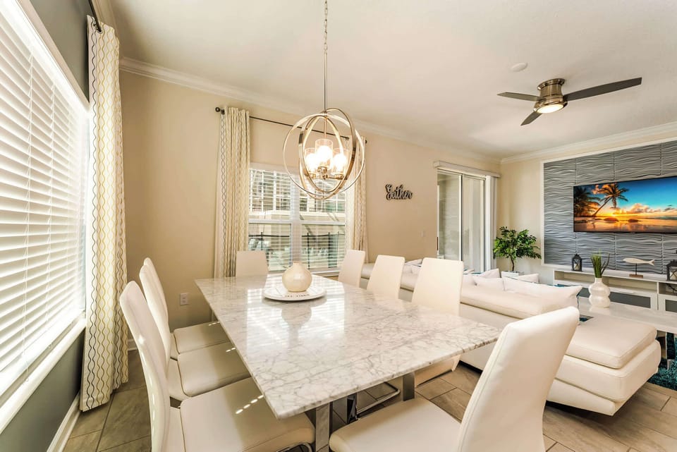 Elegant dining area with a marble table and chic chandelier, perfect for family gatherings.