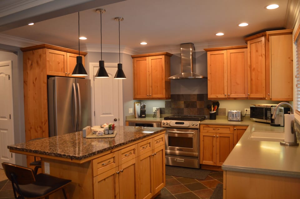 Kitchen with pantry & large side-by-side refrigerator and lower freezer drawer.