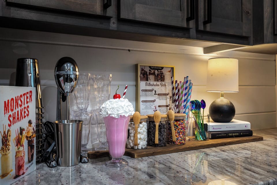 Shake things up at our fun Milkshake Bar! Craft sweet creations with our milkshake machine and provided toppings. Enjoy poolside, by the swings, or on the cozy back patio with milkshake spoons, straws and cups for a sweet experience!