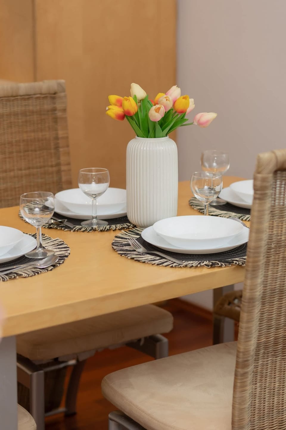 A close-up of the dining table set with tulips, plates, and decorative elements.
