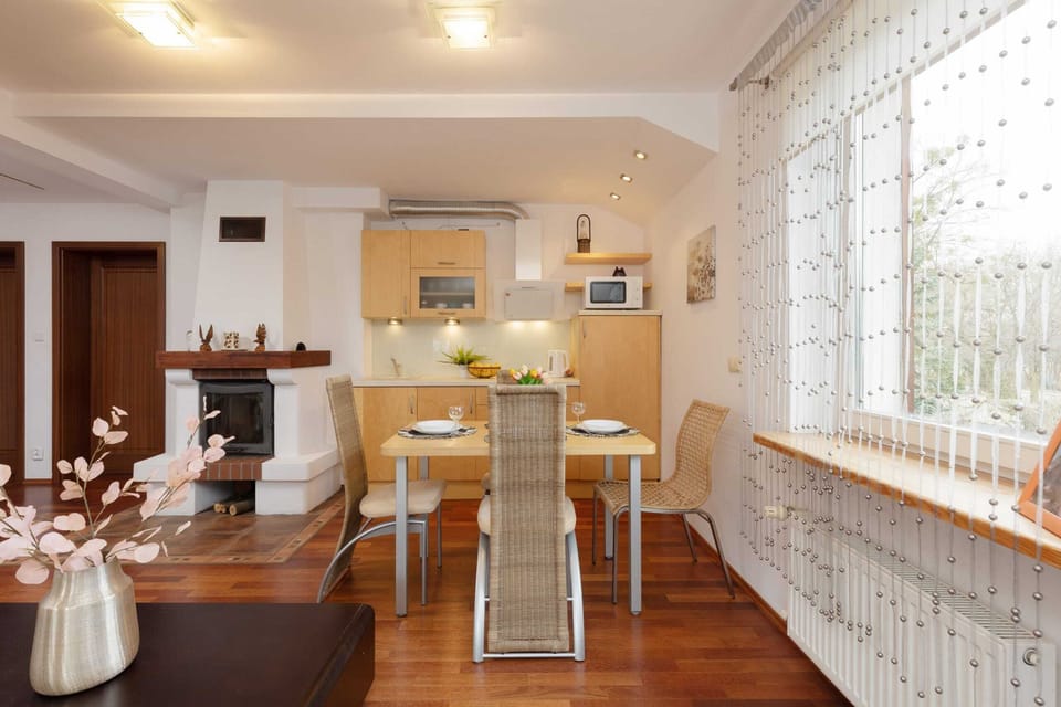 A dining area with a large table, chairs, and ample natural light from the large windows.
