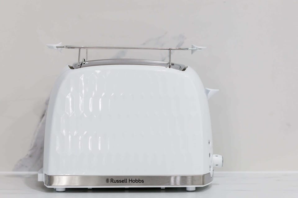 A retro-style white toaster on a countertop, adding charm to the kitchen decor.

